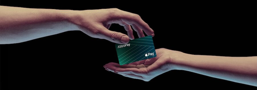 Karta AstroPay podawana z jednej dłoni do drugiej.